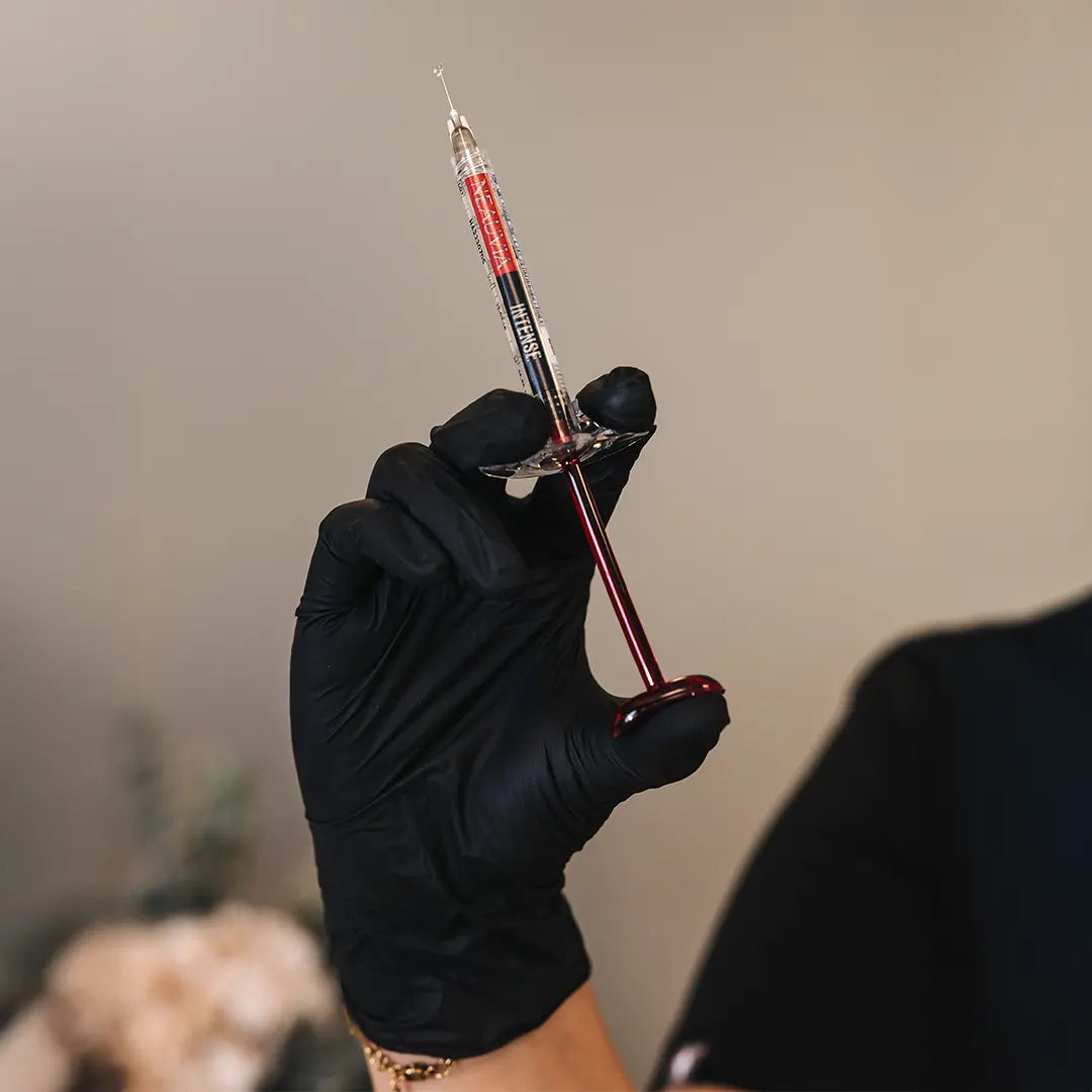 Nálmynd af fylliefnissprautu sem notuð er við Gelísprautun á Húðfegrun, haldið á lofti af hjúkrunarfræðingi í björtu og hreinu umhverfi kliníkurinnar, með Neauvia Organic fylliefni sem er eitt það hreinasta á markaðnum.